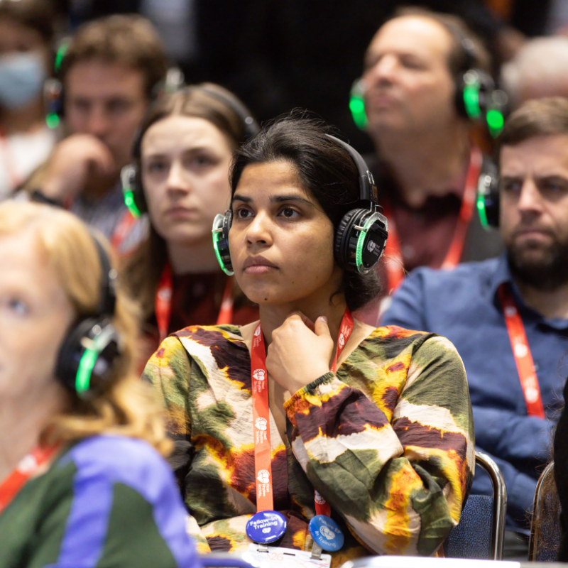 Attendees wearing wireless headphones listen attentively during a session at Heart Rhythm 2026